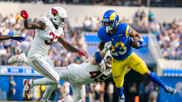 Los Angeles Rams running back Kyren Williams (23) runs the football against Arizona Cardinals cornerback Antonio Hamilton Sr. (33) and linebacker Dennis Gardeck (45) during the third quarter at SoFi Stadium